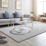 A round coffee table with a metal frame, the surface is made of chrome-plated acrylic glass.